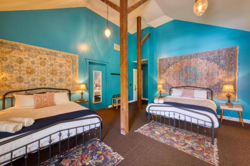 2 camas en una habitación con paredes azules en HI Sacramento Hostel, en Sacramento