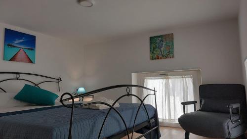 a bedroom with a bed and a chair at Home & Bed Spartano in Sapri