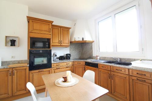 une cuisine avec des armoires en bois et une table en bois dans l'établissement Les Nuits Bonneuilloises Le Shetland, à Breteuil