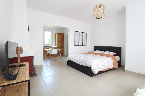 1 dormitorio con 1 cama, TV y mesa en Les Nuits Bonneuilloises Le Shetland, en Breteuil