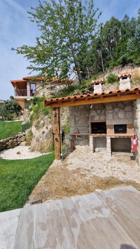 a stone building with a roof on top of it at CASA DO SOL , Turismo Rural in Celorico de Basto