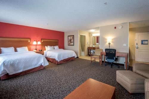 a hotel room with two beds and a desk at Hampton Inn Enterprise in Enterprise