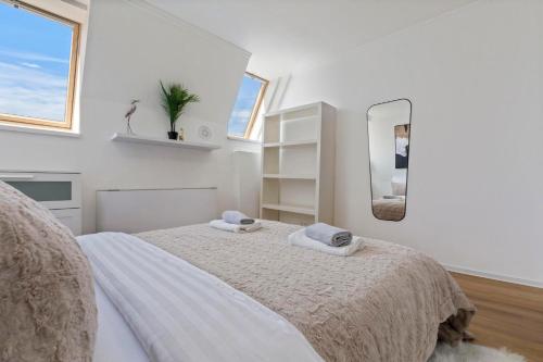 a white bedroom with a bed and a mirror at Family Hub in Centre in Bratislava