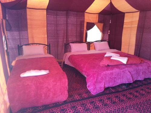 a room with two beds in a tent at Erg Chebbi Luxury Camp in Merzouga