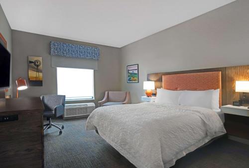 a hotel room with a bed and a desk and chair at Hampton Inn Keokuk in Keokuk