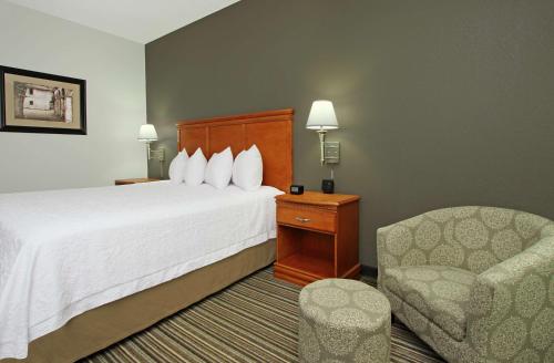 a hotel room with a bed and a chair at Hampton Inn Ashtabula in Austinburg