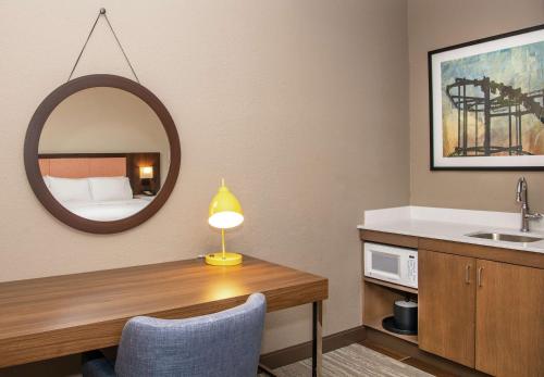 a bathroom with a desk with a sink and a mirror at Hampton Inn Erie-South in Erie