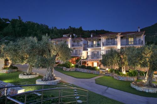 a large building with trees in front of it at Evlalia Studios & Villas in Skopelos Town