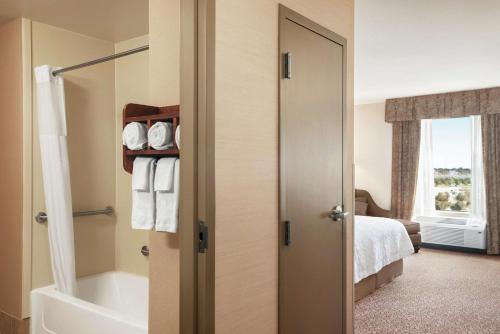 Hampton Inn & Suites West Bend في West Bend: حمام مع دش وحوض استحمام