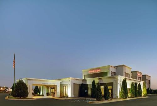 un gran edificio blanco con árboles delante de él en Hampton Inn Farmington en Farmington