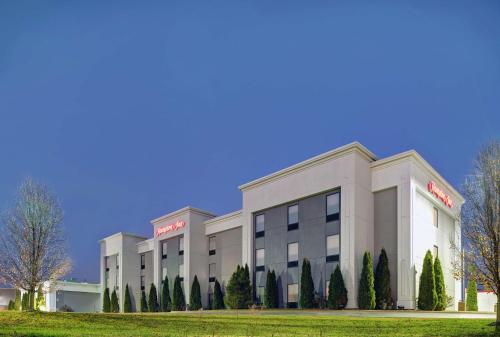 un edificio de hotel con árboles delante de él en Hampton Inn Farmington en Farmington