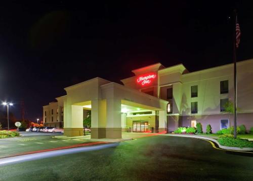 a hotel building with a lit up sign at night at Hampton Inn North Brunswick NJ in North Brunswick