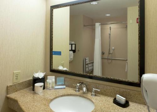 a bathroom with a sink and a large mirror at Hampton Inn North Brunswick NJ in North Brunswick