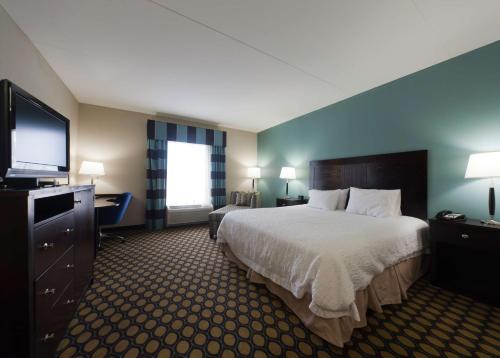 a hotel room with a bed and a flat screen tv at Hampton Inn North Brunswick NJ in North Brunswick