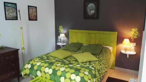 a bedroom with a green bed with green pillows at Hotel Casa Grande in Constantina