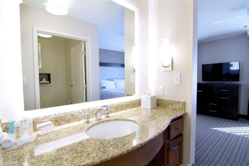 a bathroom with a sink and a large mirror at Homewood Suites by Hilton Fargo in Fargo