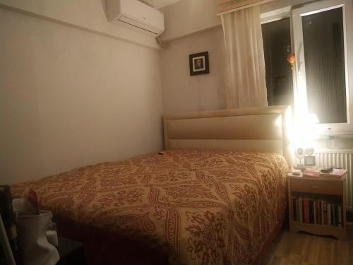 a small bedroom with a bed and a window at Etiler Akmerkez karşısı 2+1 Metroya 5 dk in Istanbul
