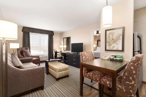 a hotel room with a desk and a living room at Homewood Suites by Hilton Fargo in Fargo