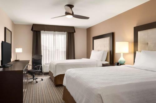 a hotel room with two beds and a television at Homewood Suites by Hilton Fargo in Fargo