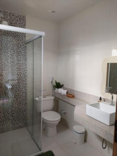 La salle de bains est pourvue de toilettes, d'un lavabo et d'une douche. dans l'établissement Pousada Cantinho de Deus, à Conservatória