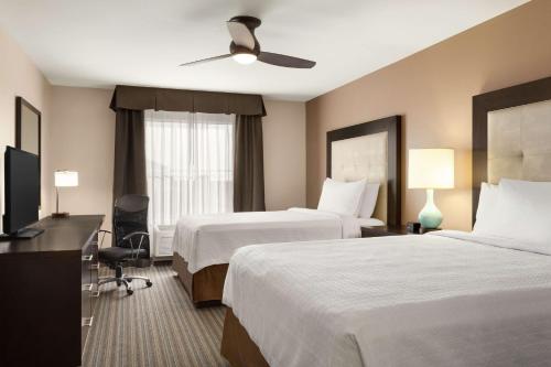 a hotel room with two beds and a television at Homewood Suites by Hilton Fargo in Fargo