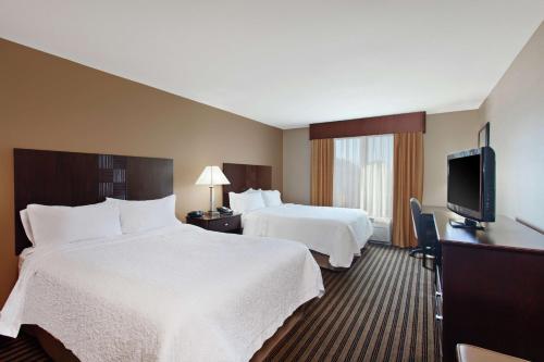 Habitación de hotel con 2 camas y TV de pantalla plana. en Hampton Inn & Suites Fresno - Northwest en Herndon