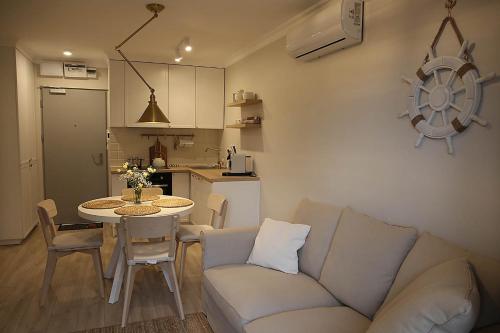 ein Wohnzimmer mit einem Sofa und einem Tisch sowie eine Küche in der Unterkunft Apartament nad Zegrzem 206 Luksus in Serock