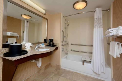 W łazience znajduje się wanna, umywalka i prysznic. w obiekcie Hampton Inn Fayetteville Fort Liberty w mieście Fayetteville