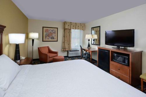 Habitación de hotel con cama y TV de pantalla plana. en Hampton Inn Fayetteville Fort Liberty, en Fayetteville