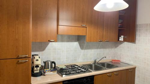 a kitchen with a sink and a stove and cabinets at Il Ciliegio in Stella Cilento
