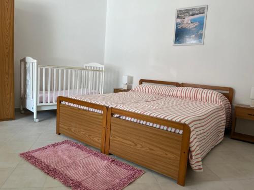 una camera con letto, culla e tappeto di SA DOMU DE S'ORTU a Bari Sardo