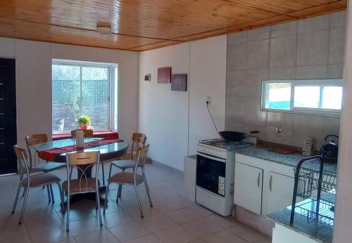 门多萨Acogedora casa para relax en Mendoza的房间里有一张桌子和几把椅子的厨房