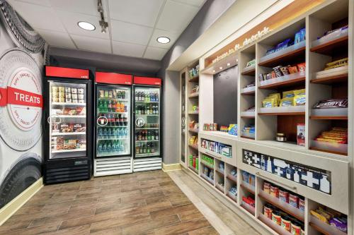 a grocery store aisle with refrigerators and shelves of food at Hampton Inn & Suites Frederick/Fort Detrick in Frederick