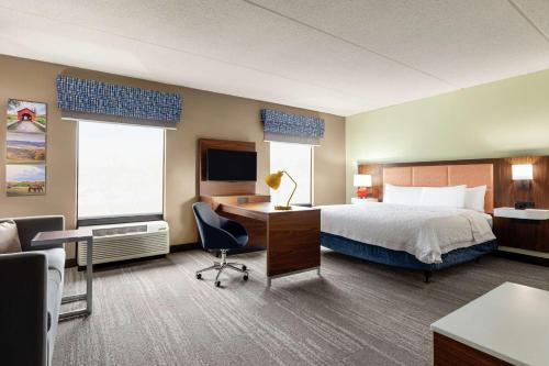 a hotel room with a bed and a desk at Hampton Inn & Suites Frederick/Fort Detrick in Frederick