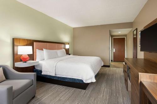 a hotel room with a bed and a flat screen tv at Hampton Inn & Suites Frederick/Fort Detrick in Frederick