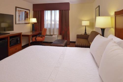 a hotel room with a large bed and a television at Hampton Inn Frederick in Frederick