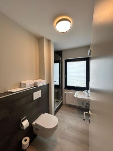ein Bad mit einem WC und einem Waschbecken in der Unterkunft Hotel Paulushof in Simmerath