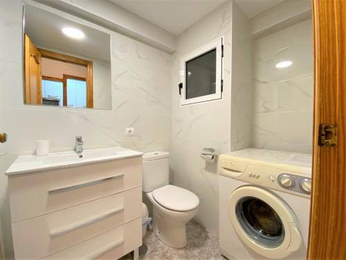 een badkamer met een toilet en een wasmachine bij Carabelas-3-12 in Benidorm