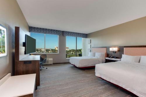 a hotel room with two beds and a flat screen tv at Hampton Inn & Suites Fort Lauderdale - Miramar in Miramar