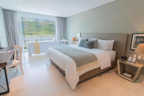 1 dormitorio con cama grande, mesa y bañera en GHL San Lazaro Art Hotel en Cartagena de Indias