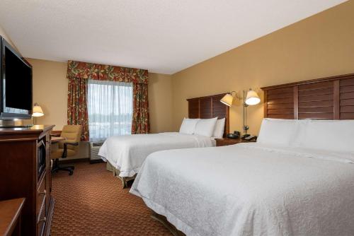 a hotel room with two beds and a flat screen tv at Hampton Inn & Suites Florence-North-I-95 in Florence