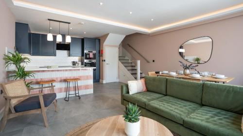 a living room and kitchen with a green couch at Lamington Apartments - London Hammersmith in London