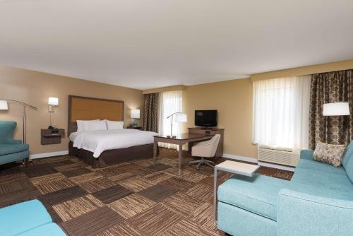 a hotel room with a bed and a couch at Hampton Inn & Suites Fremont in Fremont