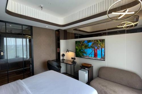 - une chambre avec un lit, une chaise et un lustre dans l'établissement Cozy Studio at Amarta Apartment, à Yogyakarta