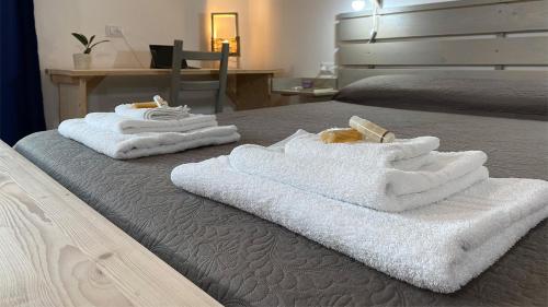 duas pilhas de toalhas sentadas numa cama em I tre schen em Calasetta