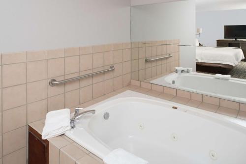 a bathroom with a tub and a large mirror at Hampton Inn North Sioux City in North Sioux City
