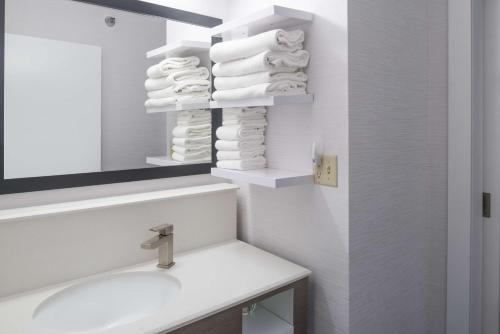 a bathroom with a sink and a mirror and towels at Hampton Inn North Sioux City in North Sioux City