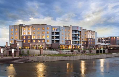 a row of buildings next to a river at Hilton Garden Inn Sioux Falls Downtown in Sioux Falls