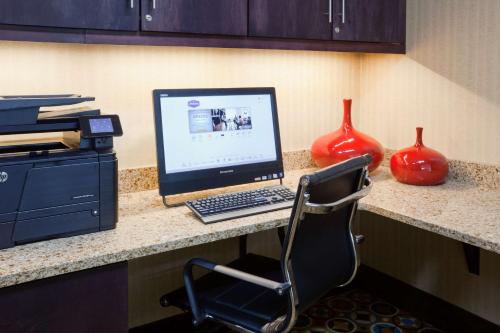 a computer sitting on a desk with a chair at Hampton Inn North Sioux City in North Sioux City