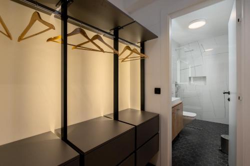 a bathroom with a vanity with hangers and a toilet at Levanat in Dubrovnik